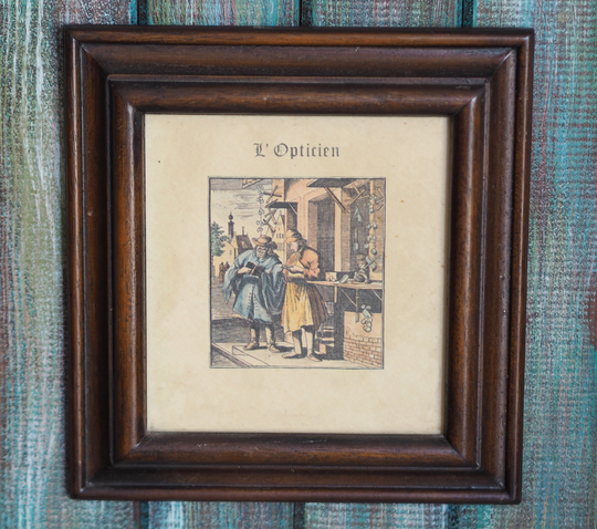 L'opticien - Antique French Hand-Colored Drypoint, Colored Drypoint Wooden Frame, Antique, Excellent Quality